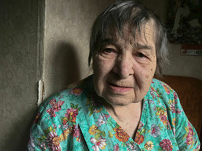 My Grandmother is cutting old clothes sitting in her armchair, Russia, Krasnoufimsk. May 2025.