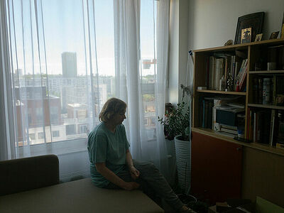 My mother in their appartment in front of a doll they call Mariia. May 2025.